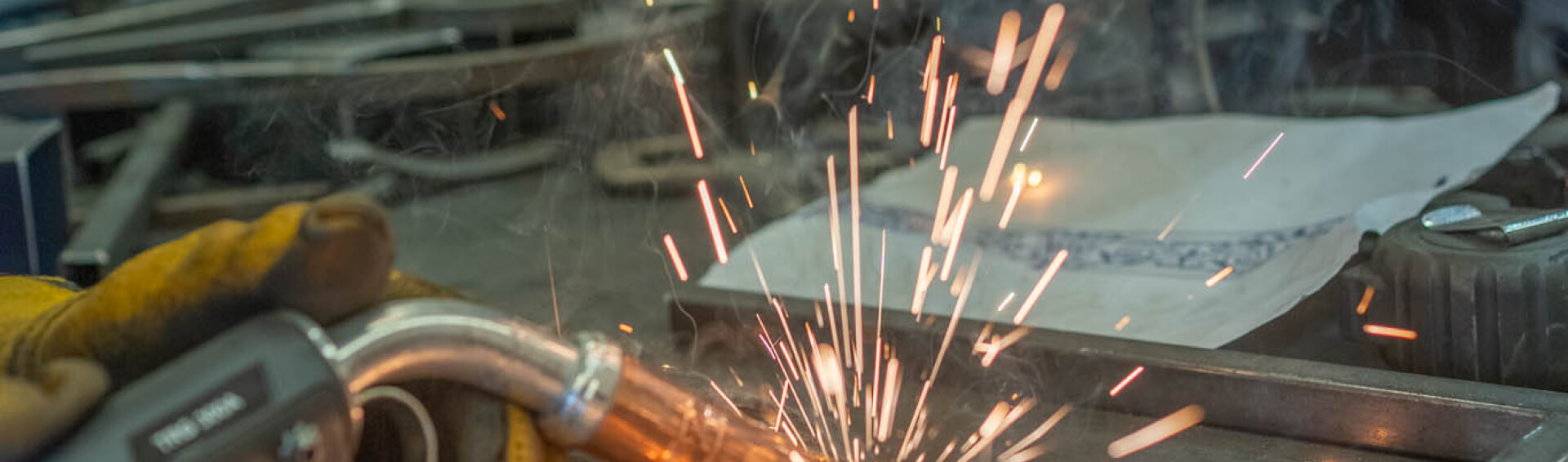 kintoart individual engaged in welding with vibrant sparks flying as metal is fused together