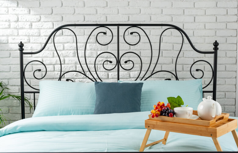 kintoart stylish bed with a blue comforter complemented by a tray displaying a cup of tea