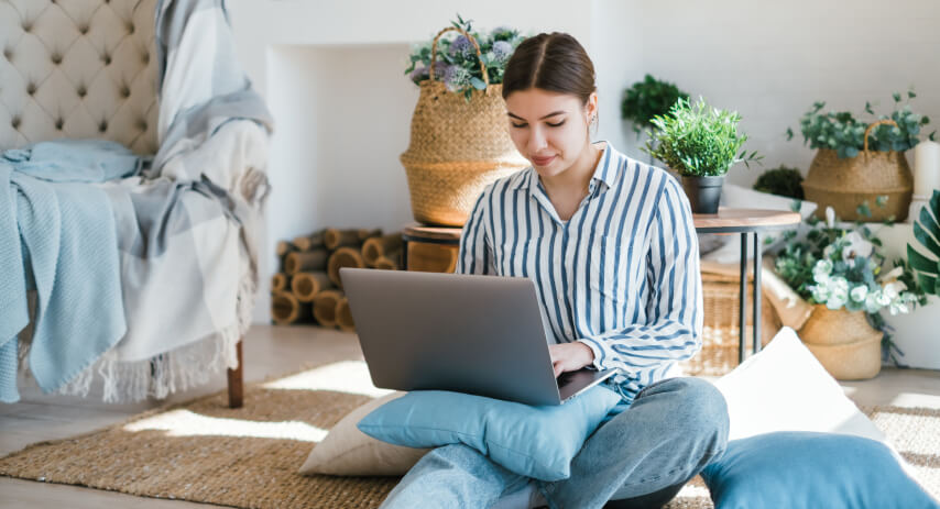 kintoart woman on the floor working intently on her laptop embodying a casual yet dedicated workspace