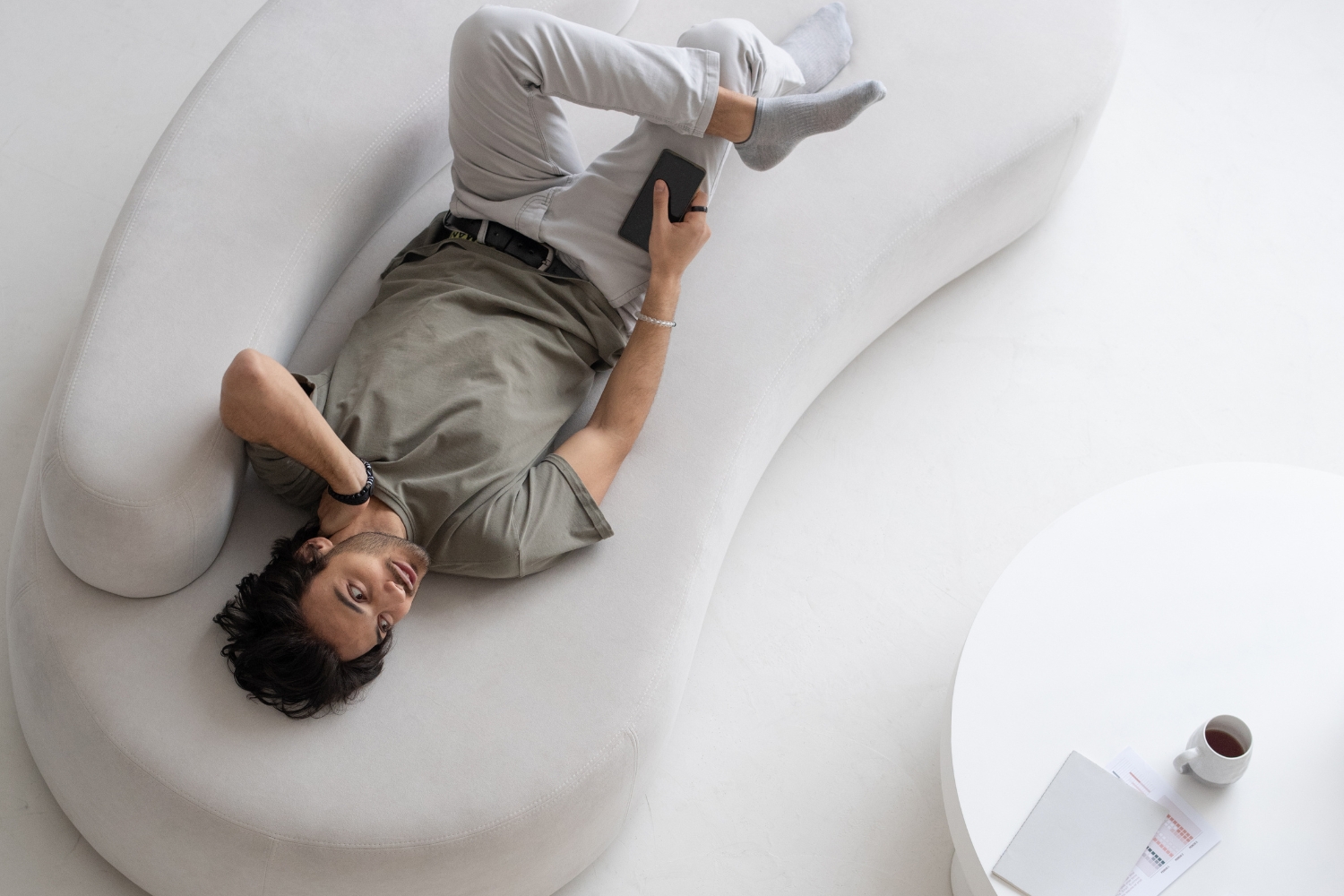 Kinto Art Blog Images curved furniture trend 2025 man laying on curved couch